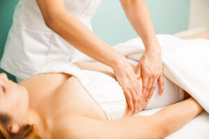 Therapist using gentle hand movements on a client’s abdomen