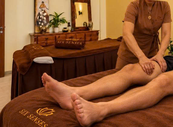 Therapist massaging a client’s thigh at Six Senses Asian Massage & Spa
